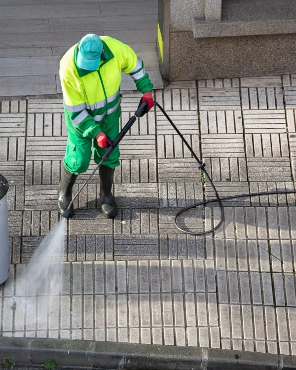 Sweeper cleaning a street sidewalk with high pressure water jet machine