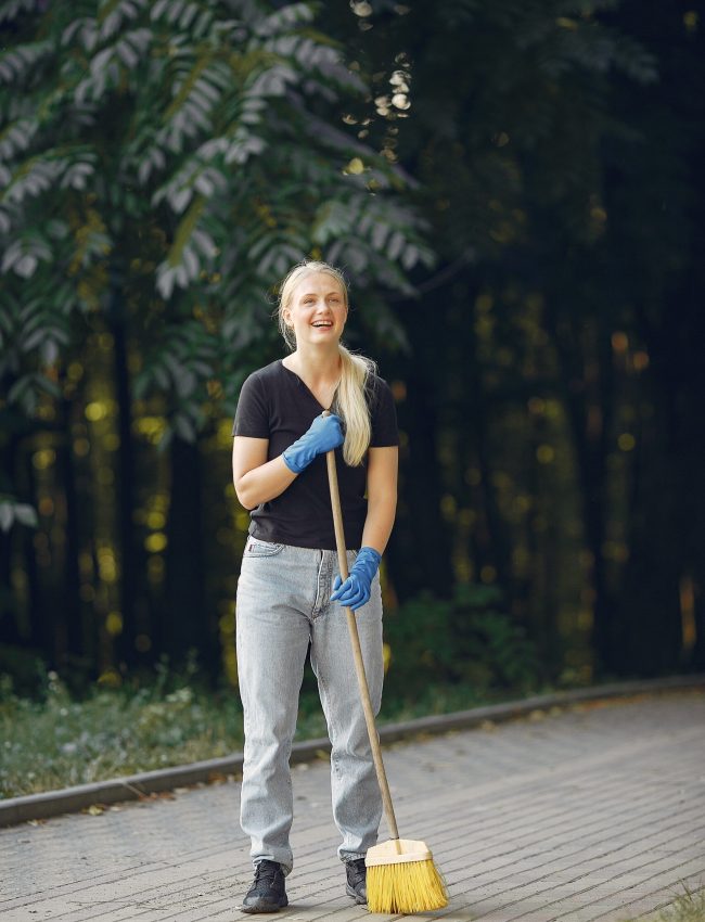 Volunteer collects leaves. Woman in a park. People cleans the park